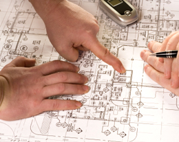 engineers pointing to blueprints